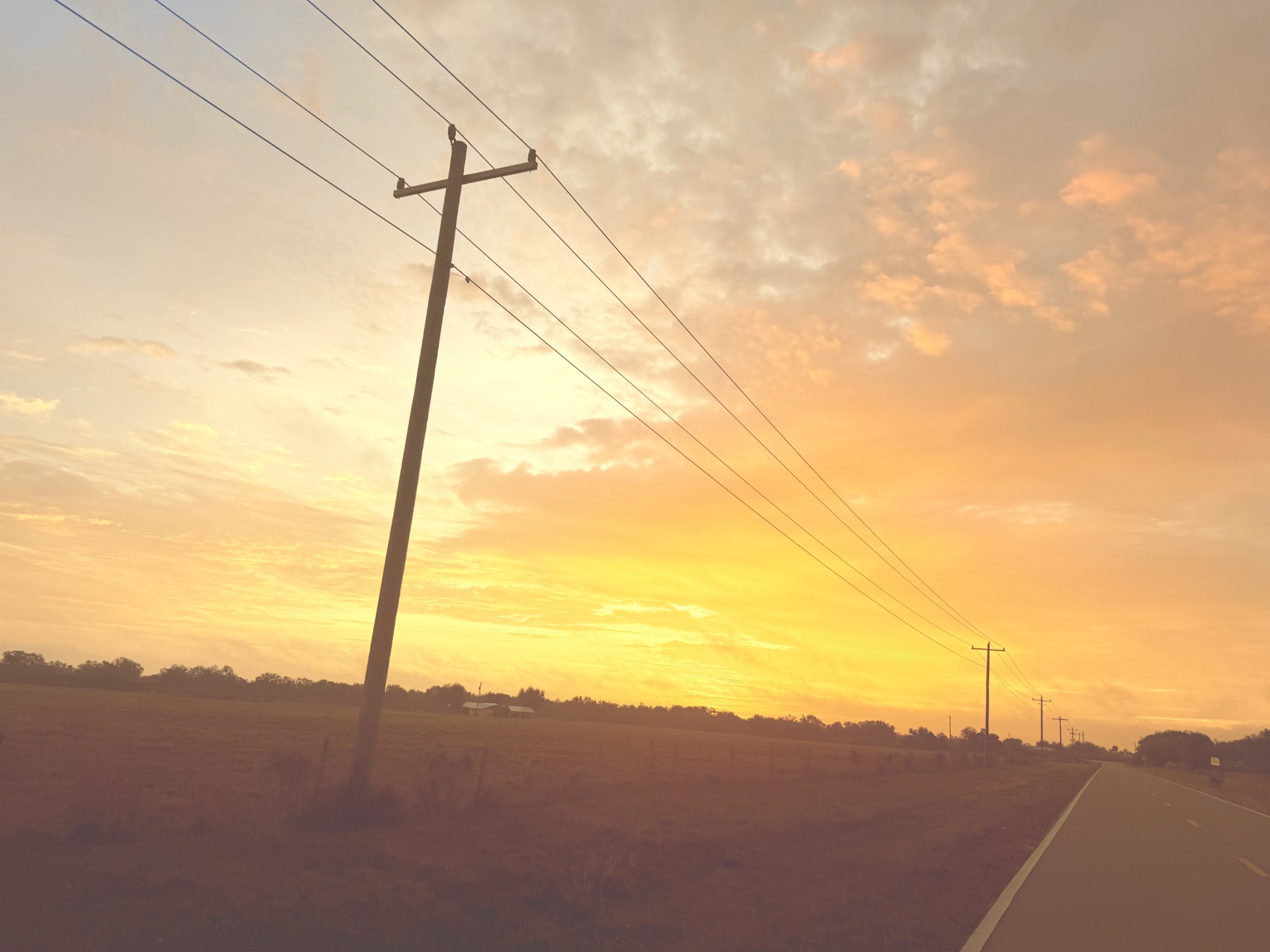 Golden sunset over a country road, pasture and power lines in Ona, Florida